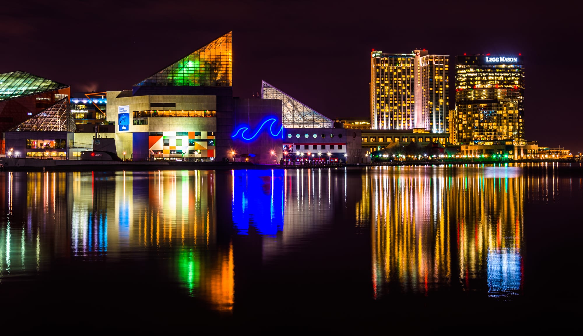 November's Fun-Filled Adventures Near FanAtlas Baltimore! A city building stands tall, mirrored in the tranquil waters nearby.