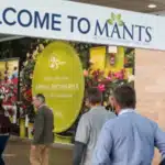 People enter an event space under a sign that reads
