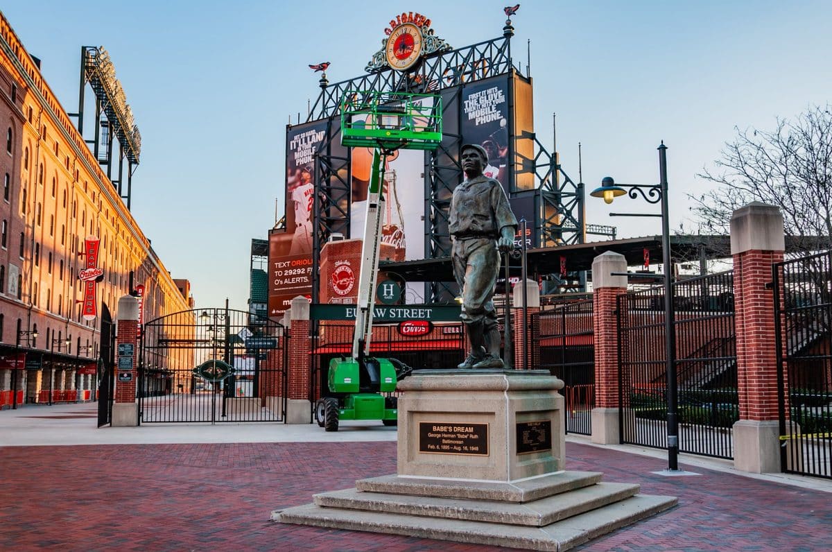 Babe's Dream statue on Eutaw Street with the B&O Warehouse and Orioles scoreboard at Camden Yards